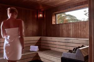 Rückansicht einer Frau in einem weißen Handtuch in der Sauna des Grecian Bay Hotels.