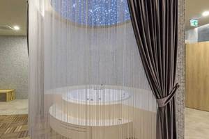 Jacuzzi im Wellnessbereich des Royal Seginus Hotels mit Sternenhimmel-Decke und Vorhängen.
