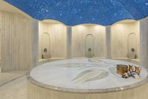 Innenansicht des Spas im Royal Seginus Hotel mit runden Marmortisch und Sternenhimmel.