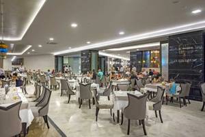 Innenbereich des Royal Seginus Hotels, mit vielen Gästen im Restaurant sitzend.