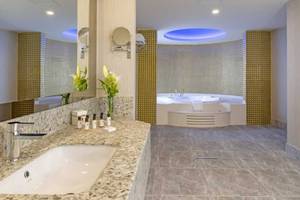Badezimmer im Royal Seginus Hotel mit Whirlpool und großer Spiegelfläche