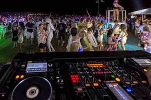 DJ-Event auf der Dachterrasse des Royal Seginus Hotels bei Nacht mit vielen Gästen und bunten Lichtern