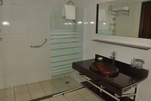 Badezimmer im Magic Tulip Resort mit Glasdusche, Waschbecken und Spiegel.