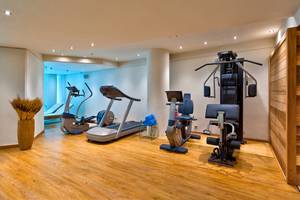 Fitnessraum im Kriti Beach Hotel mit Laufband, Rudergerät und Liegebank.