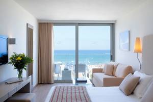 Hotelzimmer im Kriti Beach mit Meerblick, inklusive Sofa, Bett, Fernseher und Dekor.