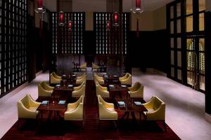 Innenansicht des Restaurants im Anantara Eastern Mangroves Abu Dhabi Hotel mit gelben Stühlen und Tischen.