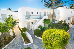 Außenansicht des Adele Beach Hotels mit weißen Gebäuden, Treppen und gepflegten Gärten.