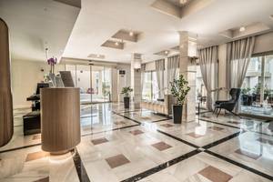 Empfangsbereich des Adele Beach Hotels mit Marmorboden und Sitzbereich.