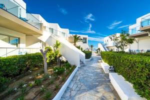 Foto des Eingangsbereichs des Adele Beach Hotels mit weißen Gebäuden und Gehweg