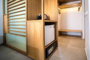 Ein Zimmerschrank im Adele Beach Hotel mit Minibar, Safe und Kaffeemaschine.