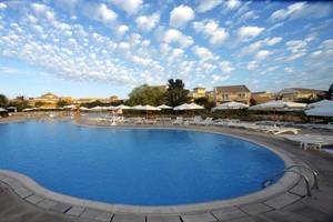 Außenpool des Mövenpick Resort & Spa El Gouna mit weißen Sonnenliegen und Sonnenschirmen.