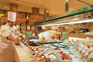 Ein Koch im Mövenpick Resort & Spa El Gouna bereitet ein Buffet zu.