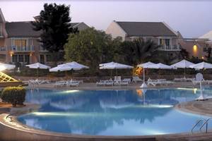 Pool im Mövenpick Resort & Spa El Gouna mit weißen Sonnenschirmen und Liegestühlen.