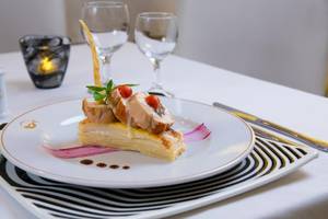 Gedeckter Tisch im Grand Sirenis Riviera Maya Resort & Spa mit einem Gericht aus Fleisch und Gemüse.