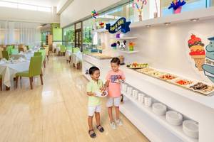 Zwei Kinder stehen vor einem Buffet im Grand Sirenis Riviera Maya Resort & Spa.