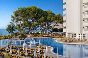 Außenpool des Roc Barlovento Hotels mit Sonnenliegen und Blick auf das Meer.
