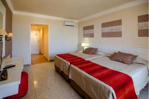 Doppelzimmer im Roc Barlovento Hotel mit zwei Betten, Fernseher und Nachttisch.
