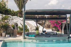 Poolbar des Kivotos Mykonos Hotels mit Sitzgelegenheiten und Pflanzen.
