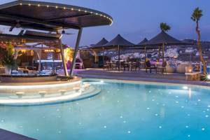 Abendansicht des Pools im Kivotos Mykonos Hotel mit Beleuchtung und umliegenden Gebäuden