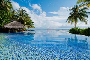 Unendlicher Pool mit Blick auf das Meer und Palmen am Kuramathi Maldives