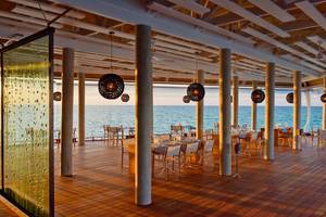 Restaurantterrasse im Kuramathi Maldives Hotel mit Blick auf das Meer.