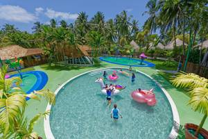 Kuramathi Maldives Außenbereich des Freizeitparks mit Pools, Spielgeräten und Kindern.