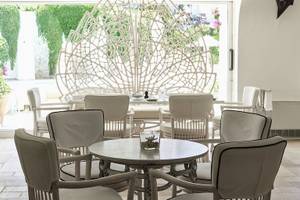 Innenbereich des Grand Hotel Poltu Quatu mit weißer Lounge und Tisch.