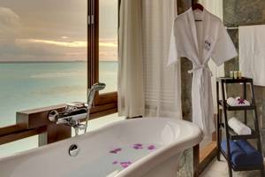 Badezimmer mit Blick auf das Meer und einem weißen Bademantel