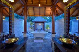 Ein Badezimmer mit freistehender Badewanne und zwei Waschbecken im Freien, Sun Siyam Olhuveli.