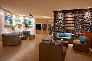 Lobby des La Pirogue Mauritius Hotels mit Steinwand, Möbeln und Pflanzen.