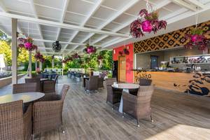 Terrasse des Akra Hotels mit Tischen, Stühlen und Pflanzen