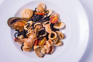 Gerichteteller Teller mit schwarzen Spaghetti, Garnelen, Tintenfisch und Muscheln auf dem Dusit Thani Laguna Phuket