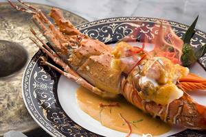 Gebratene Garnelen mit Sauce auf einem festlich dekorierten Teller im Dusit Thani Laguna Phuket