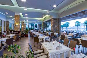 Innenansicht des Restaurants im Xanadu Island Bodrum Hotel mit gedeckten Tischen und Stühlen.