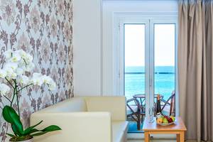 Hotelzimmer mit Meerblick, Sofa, Tisch mit Obst, und Balkontür offen