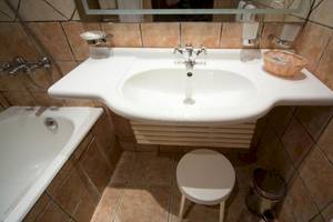 Badezimmer mit Badewanne, Waschbecken, Spiegel und Ablage