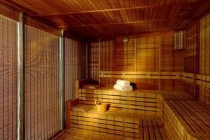 Sauna im Calista Luxury Resort mit Holzbänken und Handtuchrollen.