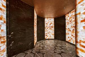 Maxx Royal Kemer Resort Innenraumdesign mit schwarzen Marmorwänden und einem Steinboden.