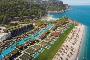 Luftaufnahme des Maxx Royal Kemer Resorts mit Pools, Gebäuden und Klippen am Meer