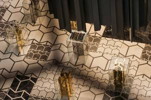 Eine Bodengestaltung des Maxx Royal Kemer Resorts mit Glastischen und Hexagonfliesen.