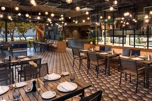 Innenbereich des Maxx Royal Kemer Resort Restaurants mit geometrischem Bodendesign und hängenden Lampen.