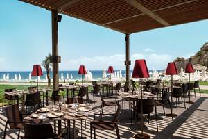 Restaurantterrasse des Maxx Royal Kemer Resorts mit Blick auf das Meer und die umliegenden Liegestühle.