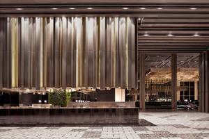 Lobby des Maxx Royal Kemer Resorts mit großen goldenen Vorhängen und moderner Einrichtung.
