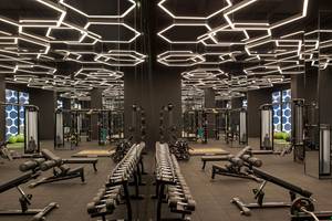 Fitnessstudio im Maxx Royal Kemer Resort mit verschiedenen Geräten und einer gemusterten Decke.