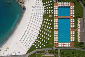 Luftaufnahme des Maxx Royal Kemer Resorts mit zwei Swimmingpools und vielen weißen Sonnenschirmen.