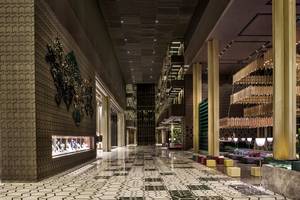 Innenbereich des Maxx Royal Kemer Resorts mit geometrischen Mustern, goldenen Säulen und Kronleuchtern.