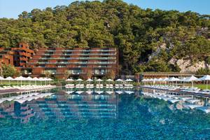 Außenbereich des Maxx Royal Kemer Resorts mit großem Pool und Sonnenliegen.