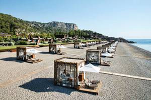 Strandlounge-Bereich im Maxx Royal Kemer Resort mit vielen Liegen und Sonnenschirmen.