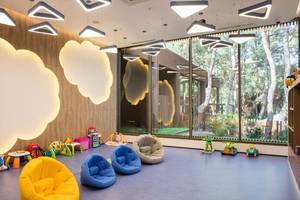 Kinderzimmer im Maxx Royal Kemer Resort mit bunten Sitzsäcken und Spielzeug vor großen Fenstern.