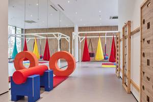 Innenbereich des Maxx Royal Kemer Resorts mit bunten Spielgeräten und Hängesesseln.